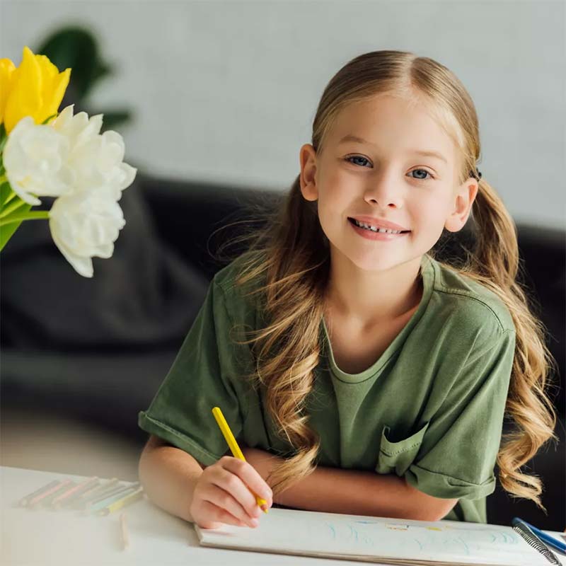 Child smiling doing homework